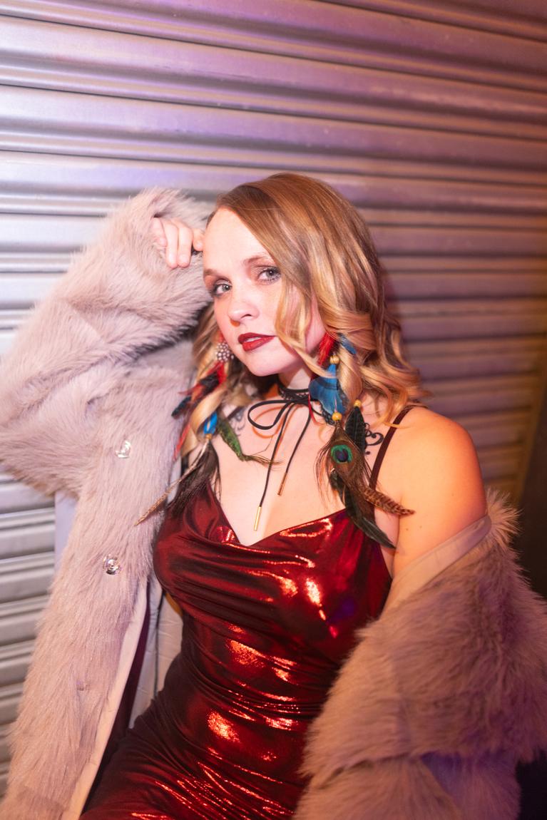 Ariel Jade leaning on a metal shutter