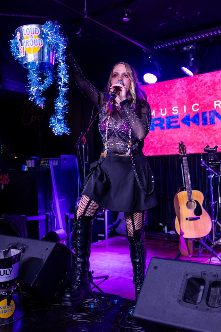 Ariel Jade on stage raising a tinsel bucket